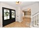 Inviting entryway featuring a double door entry, wood floors, and stylish lighting at 11708 Rolling Springs Dr, Carmel, IN 46033