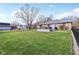 Expansive backyard featuring a well-maintained lawn, patio seating, and a secure black aluminum fence at 1194 S 300 E, Anderson, IN 46017
