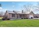 Charming brick home featuring a metal roof, attached garage, and well-manicured lawn at 1194 S 300 E, Anderson, IN 46017