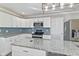 Modern kitchen boasts white cabinets, stainless steel appliances, and an island with granite countertops at 1196 S Vinewood Ave, Indianapolis, IN 46241