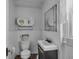 Cozy bathroom featuring a classic toilet, vanity with sink, and vintage-style mirror and window at 125 Kansas St, Indianapolis, IN 46225