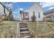 Charming home with a gabled roof, set on a raised yard with a chain-link fence and cement stairs at 125 Kansas St, Indianapolis, IN 46225
