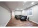 Cozy finished basement featuring wood flooring, a comfortable sectional, and natural light from a window at 12650 Misty Ridge Ct, Fishers, IN 46037