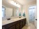 Spacious bathroom with double sinks, a large mirror, and a separate shower room with a floral curtain at 12650 Misty Ridge Ct, Fishers, IN 46037