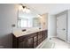 Bathroom featuring double vanity with dark cabinets, cream countertop, a large mirror, and neutral walls at 12650 Misty Ridge Ct, Fishers, IN 46037