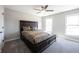Bright bedroom featuring a dark wood bedframe, ceiling fan, and natural light from two windows at 12650 Misty Ridge Ct, Fishers, IN 46037