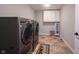 Spacious laundry room with modern washer and dryer, cabinet storage, and vinyl flooring at 12650 Misty Ridge Ct, Fishers, IN 46037