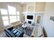 Open-concept living room with a fireplace, large windows, and stylish decor at 12650 Misty Ridge Ct, Fishers, IN 46037