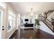 Sunlit living room features a fireplace, dark hardwood floors, and staircase at 12650 Misty Ridge Ct, Fishers, IN 46037