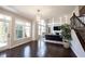 Open living area with large windows, dark hardwood floors, and adjacent staircase at 12650 Misty Ridge Ct, Fishers, IN 46037