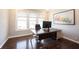 Bright home office featuring hardwood floors, large windows, and a modern desk setup at 12650 Misty Ridge Ct, Fishers, IN 46037
