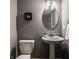 Modern bathroom with a pedestal sink, toilet, and contemporary lighting at 13306 Saxony W Blvd, Fishers, IN 46037