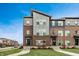 Contemporary townhouse with mixed brick and siding, complemented by a green lawn under a bright blue sky at 13306 Saxony W Blvd, Fishers, IN 46037