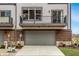 Modern townhome exterior showcasing a two car garage, brick accents, and balconies at 13306 Saxony W Blvd, Fishers, IN 46037