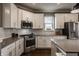 Modern kitchen with white cabinetry, stainless steel appliances, and a stylish backsplash at 13306 Saxony W Blvd, Fishers, IN 46037