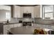 Modern kitchen with white cabinets, stainless steel appliances, and a view from the kitchen island at 13306 Saxony W Blvd, Fishers, IN 46037