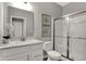 Clean bathroom with a white vanity, framed mirror, toilet, and walk-in shower featuring sliding glass doors at 15372 Hurst Rd, Fishers, IN 46040