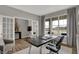 Bright home office featuring French doors, modern desk, and a view of the outdoors through large windows at 15372 Hurst Rd, Fishers, IN 46040