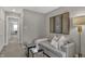 Comfortable sitting area featuring a plush sofa, modern decor, and a view of the hallway at 15372 Hurst Rd, Fishers, IN 46040