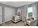 Comfortable Bedroom featuring a white crib, reading chair and large window providing natural light at 16917 Sandhurst Pl, Westfield, IN 46074