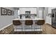 A well-lit kitchen with a central island, modern appliances, and three comfortable bar stools at 16917 Sandhurst Pl, Westfield, IN 46074