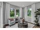 A cozy living room featuring large windows, comfortable seating, and natural light at 16917 Sandhurst Pl, Westfield, IN 46074