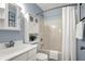 Cozy bathroom with a tub-shower combo, stylish mirror cabinet, and blue walls at 17420 Dalton Ct, Noblesville, IN 46062