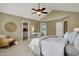 Spacious bedroom featuring a ceiling fan, desk area, and doorway to a walk-in closet and adjoining bathroom at 17420 Dalton Ct, Noblesville, IN 46062