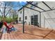 Inviting back deck with wood flooring, sliding glass doors, and black metal pergola at 17420 Dalton Ct, Noblesville, IN 46062
