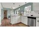 Bright kitchen with white cabinets, stainless appliances, hardwood floors, and natural light from a window at 17420 Dalton Ct, Noblesville, IN 46062
