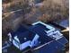 An aerial shot shows a modern home with a rooftop deck, seating area, and well-maintained landscaping and mature trees at 1818 N Cornell Ave, Indianapolis, IN 46202