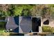 An aerial view showcases a house with a dark roof, an outdoor patio space and mature trees surrounding the property at 1818 N Cornell Ave, Indianapolis, IN 46202