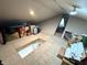 Unfinished attic space with plywood flooring, storage items, and visible insulation at 1818 N Cornell Ave, Indianapolis, IN 46202
