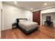 Modern bedroom with a comfortable bed, dark wood floors, and large windows at 1818 N Cornell Ave, Indianapolis, IN 46202