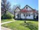 Charming home with a well-manicured lawn and inviting entrance. A blossoming tree adds curb appeal at 1818 N Cornell Ave, Indianapolis, IN 46202