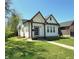 Charming exterior showcasing a well-maintained lawn and inviting facade with light colored siding and dark trim at 1818 N Cornell Ave, Indianapolis, IN 46202