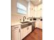 Bright kitchen with a stainless steel farm sink, white cabinets and arabesque tile backsplash at 1818 N Cornell Ave, Indianapolis, IN 46202