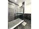 Elegant shower with black marble tiling, a glass enclosure, and gold hardware at 1818 N Cornell Ave, Indianapolis, IN 46202
