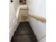 Stairwell leading down with wooden handrail and black wooden stairs at 1818 N Cornell Ave, Indianapolis, IN 46202