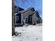 Side view of a two-story home with gray siding and white trim in a snowy landscape at 207 E Broadway St, Alexandria, IN 46001