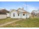Shows the exterior of a white, single-Gathering home with a chimney, a small yard, and a sidewalk leading to the entrance at 211 Jones St, Columbus, IN 47201