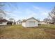 View of a detached, one-car garage with white siding in the backyard of a single Gathering home at 211 Jones St, Columbus, IN 47201