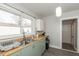 A well-lit kitchen featuring a sink, wooden countertop, and white cabinets at 211 Jones St, Columbus, IN 47201