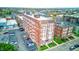 Aerial view of a brick apartment building with parking lot surrounded by urban neighborhood at 230 E 9Th St # 506, Indianapolis, IN 46204