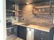 Modern kitchen features stainless steel appliances and brick accent wall with open shelving at 230 E 9Th St # 506, Indianapolis, IN 46204