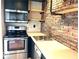 Modern kitchen features stainless steel appliances and brick accent wall with open shelving at 230 E 9Th St # 506, Indianapolis, IN 46204