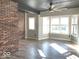 Bright living room features hardwood floors, brick accent wall, and large windows at 230 E 9Th St # 506, Indianapolis, IN 46204