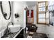 Bathroom featuring a vessel sink, decorative mirror, and tiled walls at 2417 E 80Th E St, Indianapolis, IN 46240