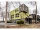 Unique house features a modern design with a stone base, green siding, and multiple windows at 2417 E 80Th E St, Indianapolis, IN 46240