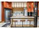 Modern kitchen features a large island with barstool seating, stainless steel appliances and bright orange walls at 2417 E 80Th E St, Indianapolis, IN 46240